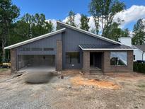 Contemporary home featuring a brick facade, modern roofline, open garage and covered front porch at 269 Deer Tail Ln # 44, Fuquay Varina, NC 27526