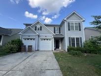 Charming two-story home featuring a two-car garage and a well-maintained front yard under a bright, partly cloudy sky at 333 Trout Valley Rd, Wake Forest, NC 27587