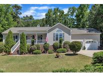 Charming single-story home with a well-manicured lawn and inviting front porch at 345 Kinsman Ct, Fuquay Varina, NC 27526