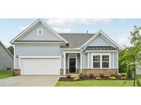 Charming home featuring light blue siding, a brick foundation, and an attached two-car garage at 529 Winding Creek Drive Dr, Lillington, NC 27546