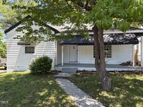 Charming one-story white home with black trim and awnings, complemented by a landscaped front yard and concrete walkway at 541 N Daughtry St, Rocky Mount, NC 27801