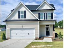 Charming two-story home featuring a two-car garage and a classic black-and-white color scheme at 58 Butterbean Ct, Zebulon, NC 27597