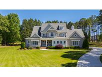 Stunning gray house boasts a manicured lawn and mature trees at 6 Castlewood Dr, Durham, NC 27713