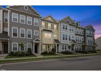 Street view of colorful, modern townhouses with landscaped front yards and ample parking at 608 Grand Central Sta, Apex, NC 27502