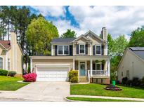 Charming two-story home with a well-manicured lawn and inviting front porch at 8613 Swarthmore Dr, Raleigh, NC 27615