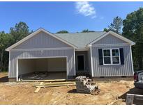 Charming single-story home with attached garage, vertical siding and blue skies above at 9254 Turkey Way, Middlesex, NC 27557
