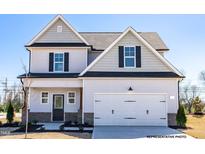Charming two-story home with a two-car garage, classic design, and tasteful gray and white color scheme at 93 Butterbean Ct, Zebulon, NC 27597