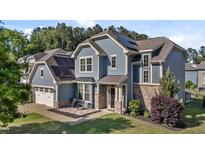 Beautiful two-story home with blue siding, stone accents, solar panels and a charming front patio at 94 Pearsall Farm Ln, Clayton, NC 27527