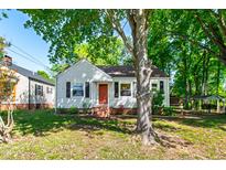 Charming single-story home with a bright red front door and mature trees in the front yard at 1003 E Club Blvd, Durham, NC 27704