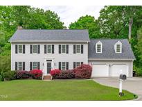 Charming two-story home with a well-manicured lawn, beautiful flowers, and a two-car garage at 1007 Wellstone Cir, Apex, NC 27502