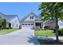 Charming home featuring a two-car garage, lovely front porch, and well-manicured lawn at 1033 Cuthbert Ln, Durham, NC 27703