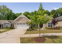 Inviting single-story home featuring a well-manicured lawn, charming landscaping and an attached two-car garage at 1129 Santa Cruz St, Wake Forest, NC 27587