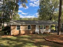 Charming single-story home with a well-maintained lawn and mature trees at 157 Thorpe St, Henderson, NC 27536