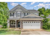 Charming two-story home with stone accents, shingle siding, attached two-car garage, and beautifully maintained landscaping at 196 Norwich Dr, Clayton, NC 27520