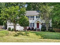 Charming two-story home with a well-manicured lawn and inviting red door at 215 Rocky Point Ct, Fuquay Varina, NC 27526