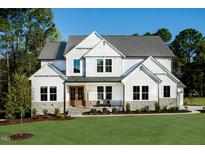Beautiful two-story home boasts a manicured lawn and inviting front porch at 219 George Hudson Rd, Siler City, NC 27344
