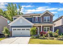 Charming two-story home with stone accents, red shutters, landscaped yard, and a two-car garage at 2217 Holtwood Way, Apex, NC 27523