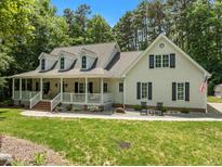 Charming two-story home featuring a welcoming front porch, dormer windows, and beautifully landscaped front yard at 2616 Dockery Ln, Raleigh, NC 27606