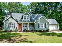 Charming single-Gathering home featuring a well-manicured lawn, a cozy front porch, and a bright red front door at 305 Monterey Ct, Benson, NC 27504