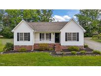 Charming home with fresh white siding, black shutters, brick accents, and meticulously maintained front yard at 3603 Westmeadow Ln, Elon, NC 27244