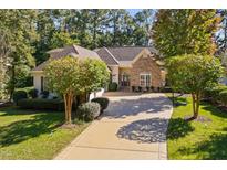 Charming single-story home featuring stone accents, a well-manicured lawn, and a long driveway at 39 Forked Pine Ct, Chapel Hill, NC 27517