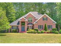 Stately brick home featuring a manicured lawn and mature landscaping at 412 Bowen Rd, Rougemont, NC 27572