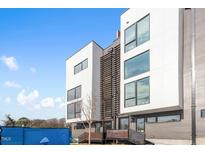 Modern townhomes with large windows and a combination of white and gray siding under a bright, blue sky at 512 Gordon St # 1006, Durham, NC 27701