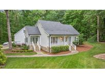 Charming, bright white cottage-style home with a welcoming front porch and lush green lawn at 5241 Mill Dam Rd, Wake Forest, NC 27587