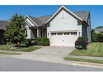 Charming single-Gathering home with a two-car garage, landscaped yard, and light gray siding at 8461 Lentic Ct, Raleigh, NC 27615