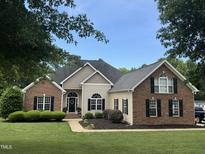 Beautiful single Gathering home featuring brick and siding, manicured lawn, and well-maintained landscaping at 95 Live Oak Dr, Louisburg, NC 27549