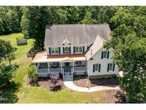 Aerial view of a two-story home featuring a wrap-around porch and green shutters surrounded by mature trees at 101 Rainbow Dr, Carrboro, NC 27510