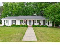 Charming brick home with a well-manicured lawn and inviting front porch at 102 Lake Dr, Wendell, NC 27591