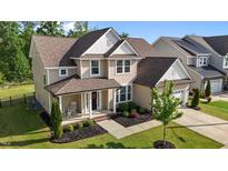 Charming two-story home with a welcoming front porch and well-manicured lawn at 1042 Cardross St, Burlington, NC 27215