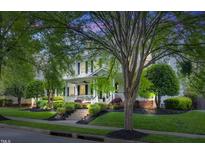 Charming two-story home with a inviting front porch and beautiful landscaping at dusk at 10523 Bedfordtown Dr, Raleigh, NC 27614