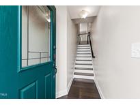 Inviting entryway with beautiful teal front door and staircase leading to the upper level of the home at 1101 Boxcar Way, Apex, NC 27502