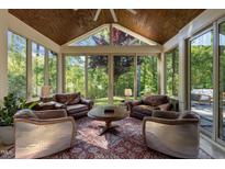 Bright sunroom featuring a wood paneled ceiling and wall-to-wall windows offering backyard views at 1103 Capstone Dr, Durham, NC 27713