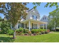 Charming two-story home with a welcoming front porch and beautifully landscaped front yard at 1104 Dominion Hill Dr, Cary, NC 27519