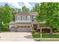 Charming two-story home featuring a three-car garage, manicured lawn, and tasteful landscaping at 1401 Everette Fields Rd, Morrisville, NC 27560
