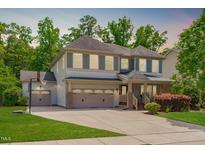 Charming two-story home featuring a three-car garage, manicured lawn, and mature landscaping at 1401 Everette Fields Rd, Morrisville, NC 27560