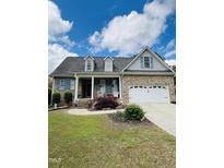 Charming brick home featuring a well-manicured lawn, dormers, and a two-car garage at 151 Donnibrook, Fuquay Varina, NC 27526