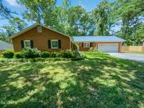 Charming single-story brick home with a well-manicured lawn and mature trees in a quiet neighborhood at 1522 Goodwin Rd, Durham, NC 27712
