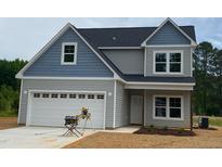 Charming two-story home with blue and gray siding, a two-car garage, and freshly laid straw at 160 Tupelo Dr, Spring Hope, NC 27882