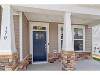 Charming blue front door with stone pillar accents and white trim welcomes you home at 170 Creekhaven Dr, Angier, NC 27501