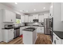 Modern kitchen features white cabinetry, stainless steel appliances, granite counters, and a functional center island at 170 Creekhaven Dr, Angier, NC 27501