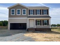 Two-story home featuring a large two-car garage and classic window shutters at 171 Alice Trace Place, Angier, NC 27501