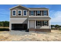 Two-story home showcasing a spacious garage, classic windows and neutral-toned siding at 171 Alice Trace Place, Angier, NC 27501