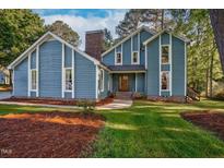Charming blue two-story home featuring bright white trim and a brick chimney at 206 Cottrell Dr, Louisburg, NC 27549
