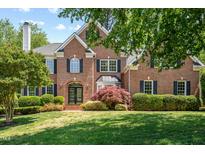 Charming brick two-story home with manicured lawn, arched entry, black shutters, and mature landscaping at 206 Glebe Way, Cary, NC 27519