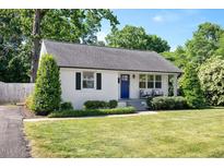 Charming single-story home featuring a landscaped yard, a blue front door, and classic black shutters at 2210 Milburnie Rd, Raleigh, NC 27610
