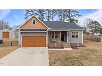Charming home with gray siding, a welcoming front porch, and a well-maintained front yard at 2690 Meadow View Ln, Sanford, NC 27332